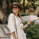 attractive woman walking in street on vacation dressed in white summer fashion dress